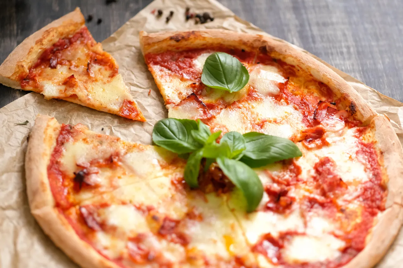 Freshly baked pizza with basil on parchment 2026 03 25 06 02 51 utc